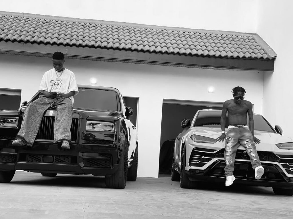 shatta wale seated on his luxury car